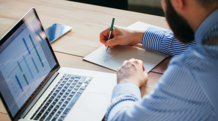 Man writing at laptop