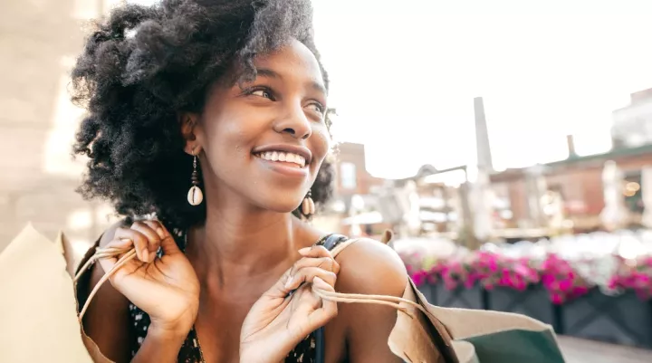 woman smiling with two shopping bags