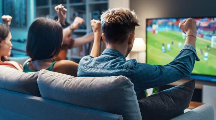 Group of friends watching a football match on TV