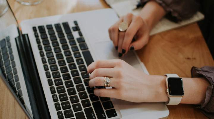 A woman's hands on a laptop's keyboard