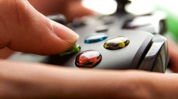 An extreme close up of a person's hands using an XBOX controller.