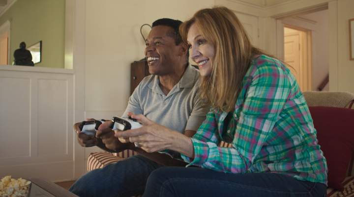 A happy couple game on console together. 