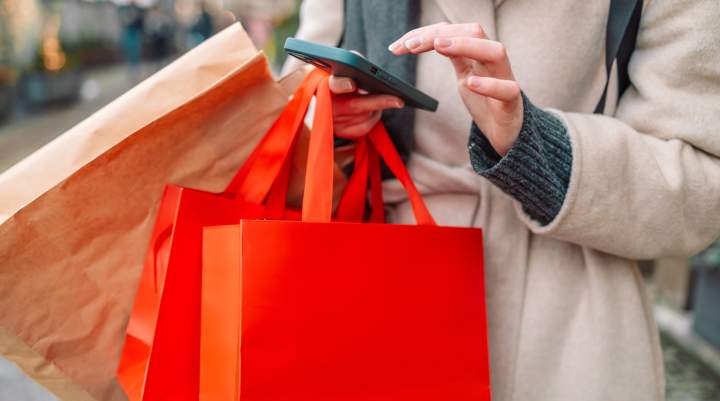 A woman playing on her phone while shopping.