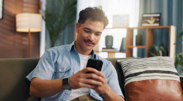 A young man plays games on his phone.